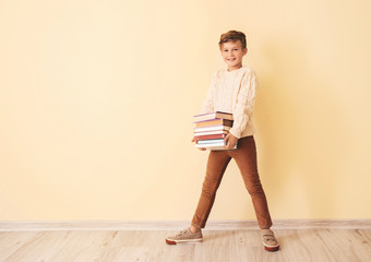 Wall Mural - Little boy with books near color wall