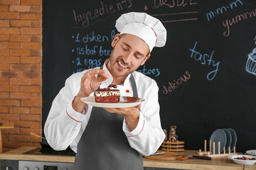 Sticker - Male chef with piece of cake in kitchen