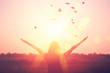 Leinwandbild Motiv Freedom and feel good concept. Copy space of silhouette woman rising hands on sunset sky background.