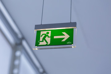 vienna, austria - jan 29, 2020: view on illuminated emergency exit sign. with running figure and arr
