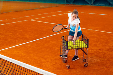 Wall Mural - Young woman playing tennis at indoor tennis court