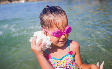 Wall Mural - Happy little girl with the seashell