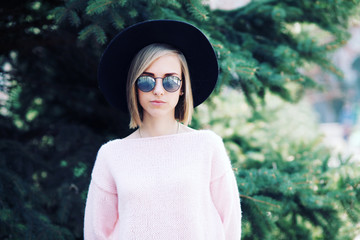 Outdoor portrait of young beautiful fashionable playful lady. Model wearing stylish hat & clothes. Sunny day.