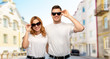 © Syda Productions - travel, tourism and vacation concept - happy couple in white t-shirts and sunglasses over city street background