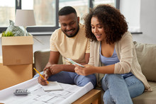 Mortgage, Moving And Real Estate Concept - Happy African American Couple With Blueprint And Calculator Counting Money For Repair Costs To New Home