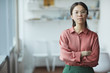 © AnnaStills - Portrait of confident young businesswoman in eyeglasses standing with arms crossed and looking at camera at office