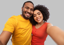 Relationships And People Concept - Happy African American Couple Taking Selfie Over Grey Background