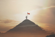 Man Plants His Flag On The Mountain Peak As A Sign Of Success