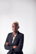 © Monkey Business - Portrait Of Determined Young Businesswoman Wearing Suit Standing Against White Studio Wall