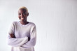 © Monkey Business - Portrait Of Smiling Young Woman Standing Against White Studio Wall