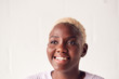 © Monkey Business - Smiling Young Woman Standing Against White Studio Wall