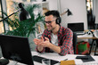 © JustLife - Businessman on video call. Handsome man in office with headphones.