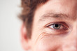 © Monkey Business - Close Up On Eyes Of Smiling Man Standing In Studio
