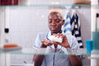 © Monkey Business - View Through Bathroom Cabinet Of Young Woman Taking Medication From Container