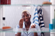 © Monkey Business - View Through Bathroom Cabinet Of Woman Getting Ready For Work And Moisturizing Skin