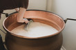 © Studiodes2Prairies - Agricultrice brasse du lait dans un chaudron