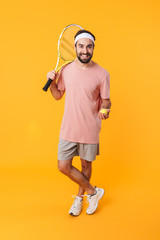 Wall Mural - Image of athletic young man holding rackets while playing tennis