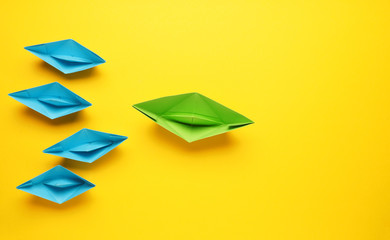Wall Mural - teamwork business concept with paper boat on yellow background