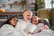 © zinkevych - Grey-haired granddad reading bedtime stories to his granddaughters