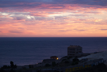 Beautiful sunset and buildings by the sea; placid and deep sea