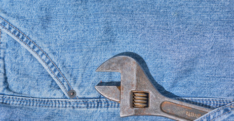 rusty wrench in jeans pocket, labor day concept