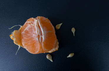 orange peeled by hand, placing orange on the floor. healthy fresh orange.design isolated on black. h