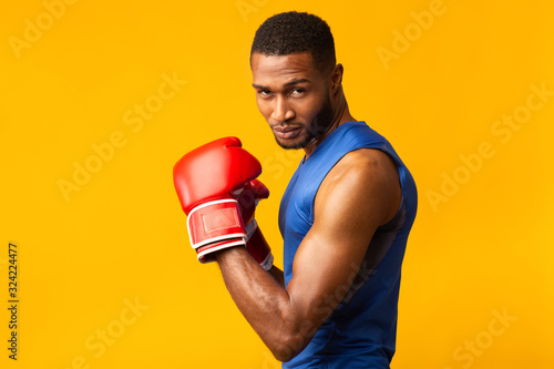 Leinwand Poster Confident black man wearing red boxing gloves
