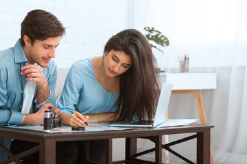 Planning trip. Young couple studying map and making notes