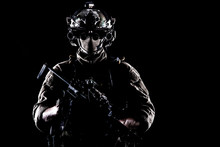 Army Elite Soldier With Hidden Behind Mask And Glasses Face, In Full Tactical Ammunition, Equipped Night Vision Device, Radio Headset, Armed Short Barrel Service Rifle Studio Contour Shot