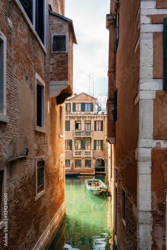 Cuadros en Lienzo Boat in narrow canal against ancient house, Venice, Italy