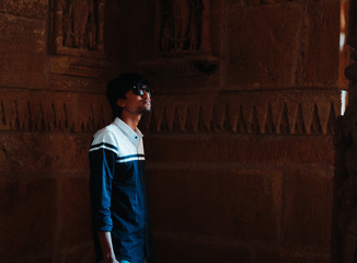 Indian male tourist standing inside the Sun Temple and looking at its architecture at Modhera, Gujarat, India