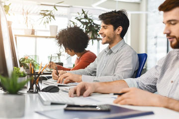 Colleagues working in front of computers in coworking space