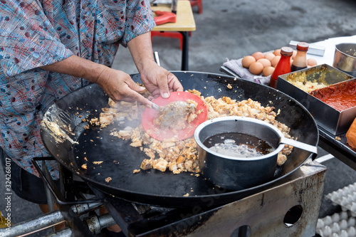 Fotomural Malaysian hawker cooking frying radish carrot cake with egg in wok