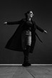 © Oleg Samoylov - Black and white fashion shot. Portrait of a fashionable girl in high boots, a long coat, jeans and sunglasses.