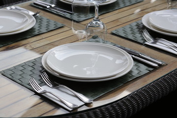 empty plate with fork and knife on wooden table