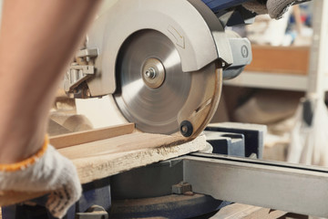 Sticker - Professional carpenter cutting wooden planks with sawmill in workshop, closeup