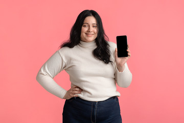 Beautiful plus size girl showing modern smartphone with black screen