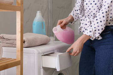 Canvas Print - Woman pouring detergent into washing machine drawer in bathroom, closeup. Laundry day