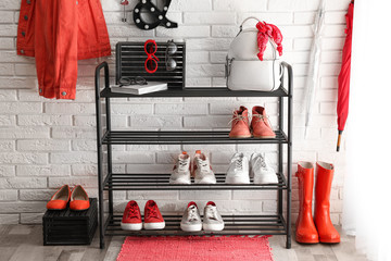 Wall Mural - Shelving rack with stylish women's shoes and accessories near white brick wall indoors