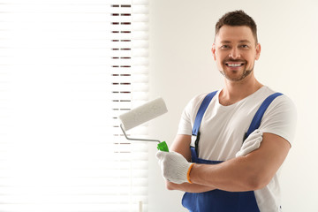 Wall Mural - Man holding paint roller near window indoors. Space for text
