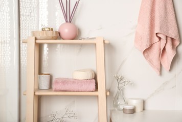 Poster - Shelving unit with towel and decorative elements in bathroom interior