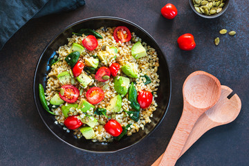 Wall Mural - Healthy salad with bulgur, avocado, spinach and cherry tomatoes. Top view.