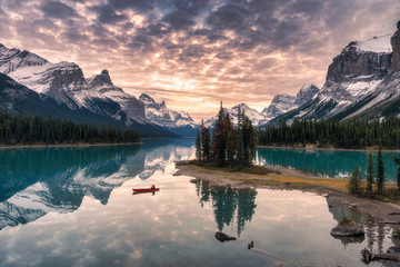 traveler canoeing with rocky mountain reflection on maligne lake at spirit island in jasper national