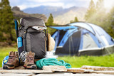 Fototapeta  - Backpack on stones and blurred blue tent.Spring trip time. 