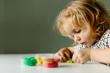 Wall Mural - the child is engaged in modeling on the table