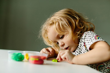 Wall Mural - the child is engaged in modeling on the table