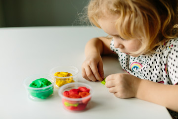 Wall Mural - the child is engaged in modeling on the table