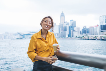 Wall Mural - Cheerful modern Asian woman on pier of city