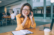© BullRun - Intrigued woman talking on phone at cafe