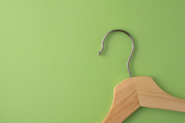 Zero waste minimalist background. Top view at one wooden hanger on green pastel backdrop.